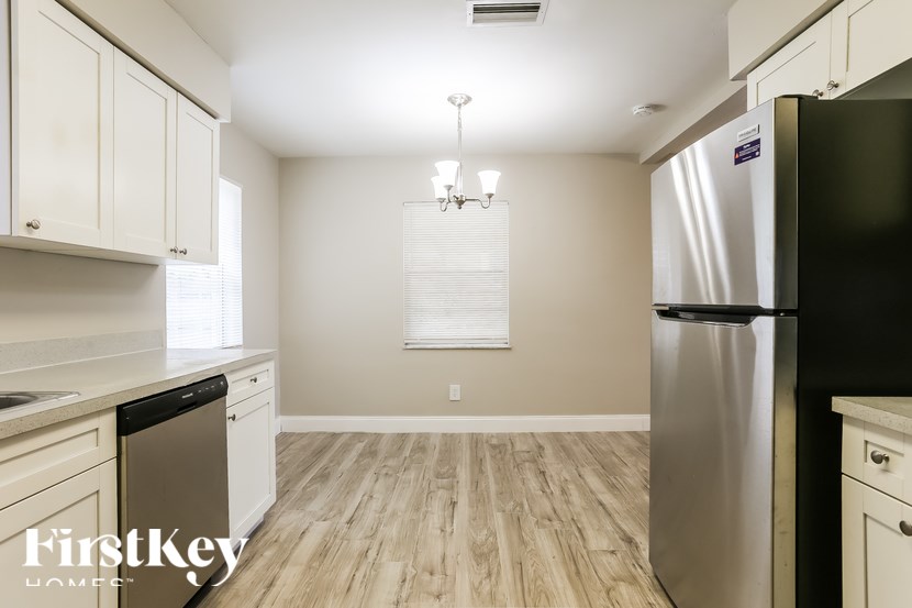 A kitchen with a refrigerator on the right and a dishwasher on the left.