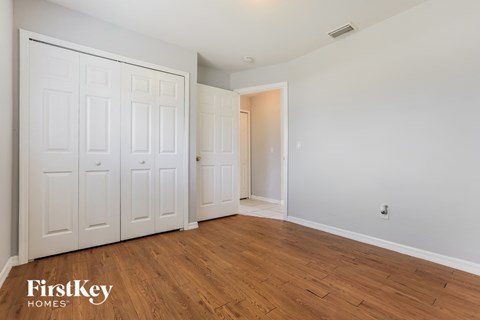 a bedroom with two closets and a hard wood floor