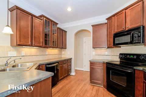 A kitchen with wooden cabinets and a stove top oven.