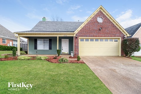 A house with a garage and a driveway in front of it.