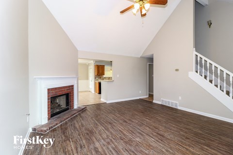 A spacious living room with a fireplace and wooden floors.