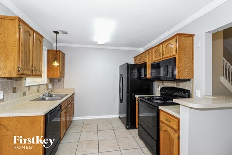 A kitchen with wooden cabinets and black appliances.