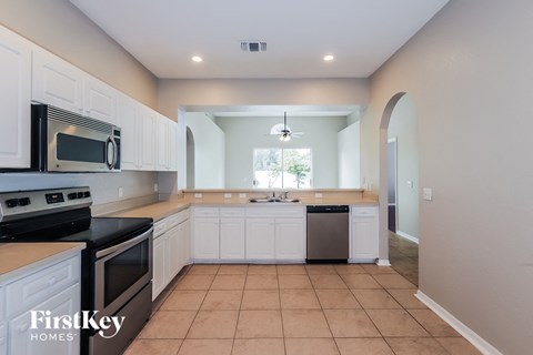 A kitchen with white cabinets and black appliances.
