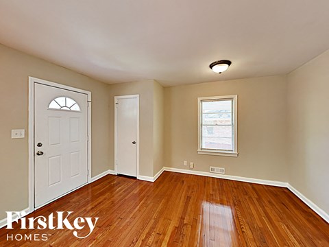 an empty living room with wood floors and a white door