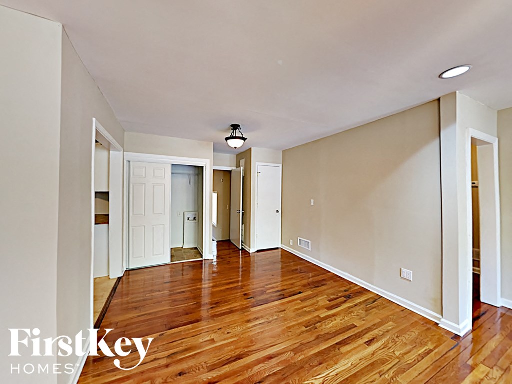 an empty living room with wood floors and white walls