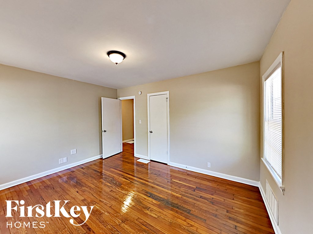 an empty living room with wood floors and white walls