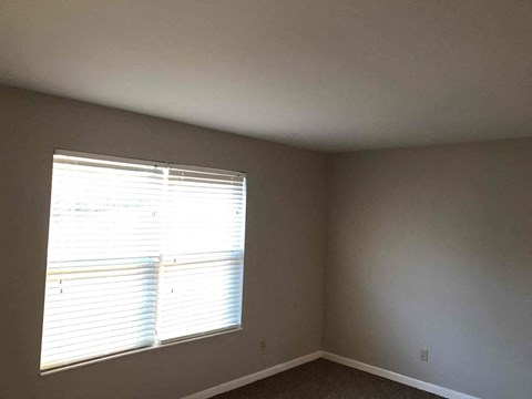 a living room with a window and gray walls