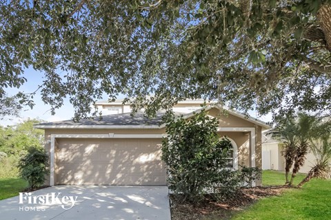 a home with a garage door and a tree