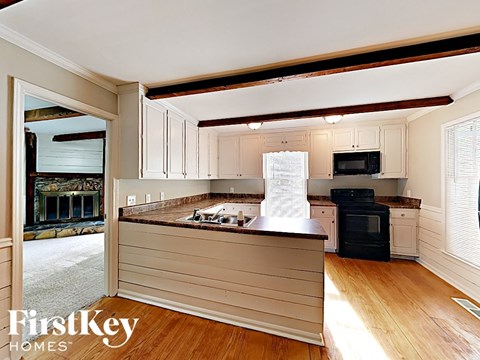 A kitchen with wooden floors and a FirstKey Homes logo.