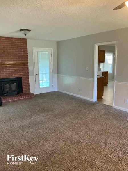 A living room with a fireplace and a carpet.