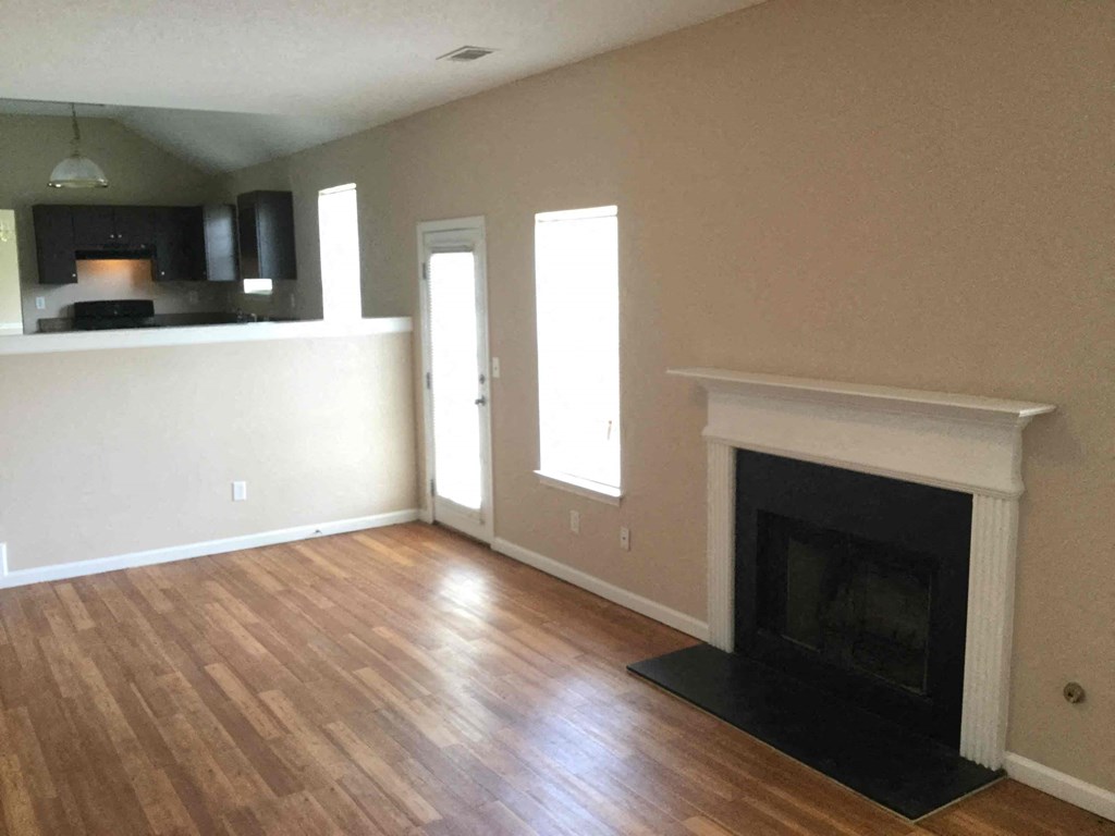 a living room with a fireplace and wooden floors