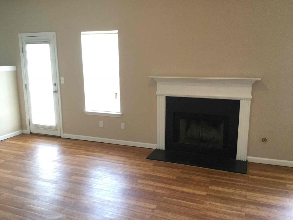 a living room with a fireplace and a wooden floor