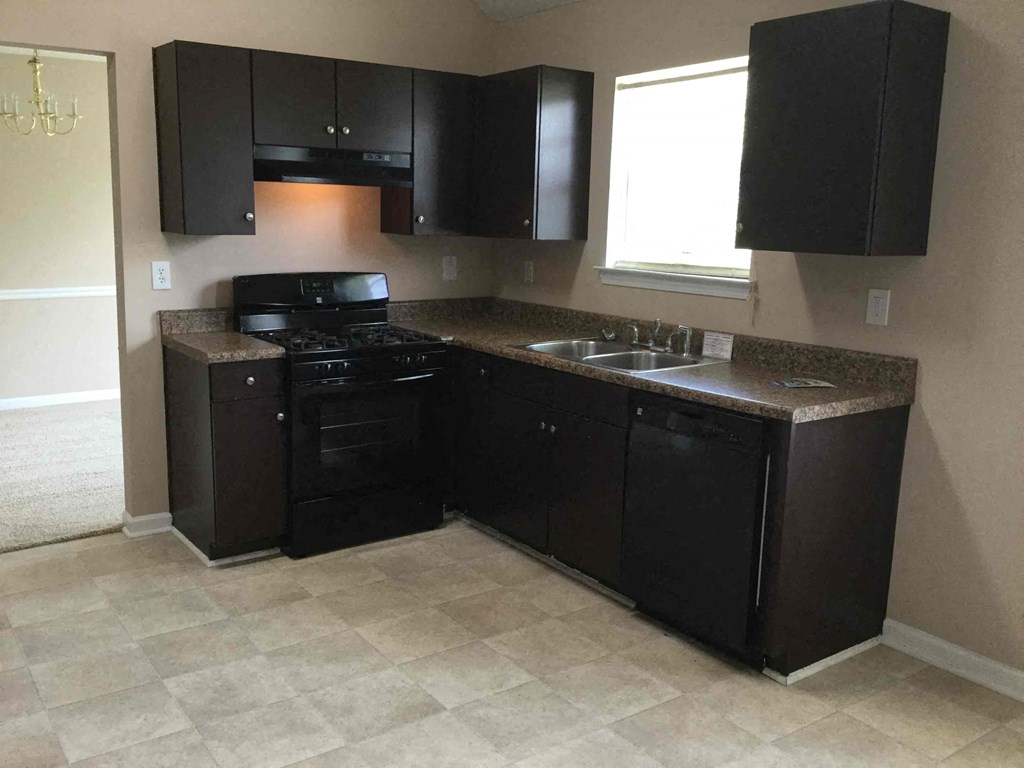 an empty kitchen with black appliances and black cabinets