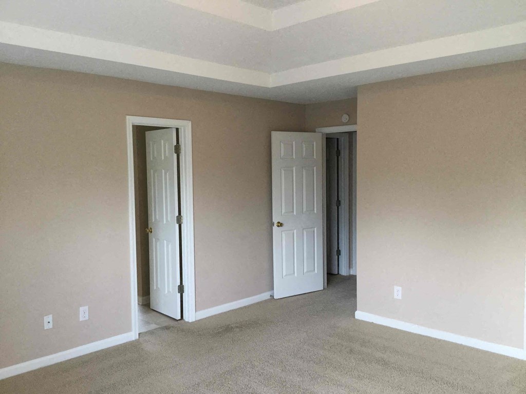 a living room with a carpeted floor and two doors