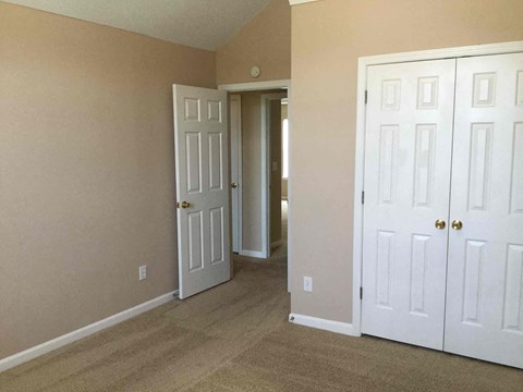 a bedroom with two closets and a door to a hallway