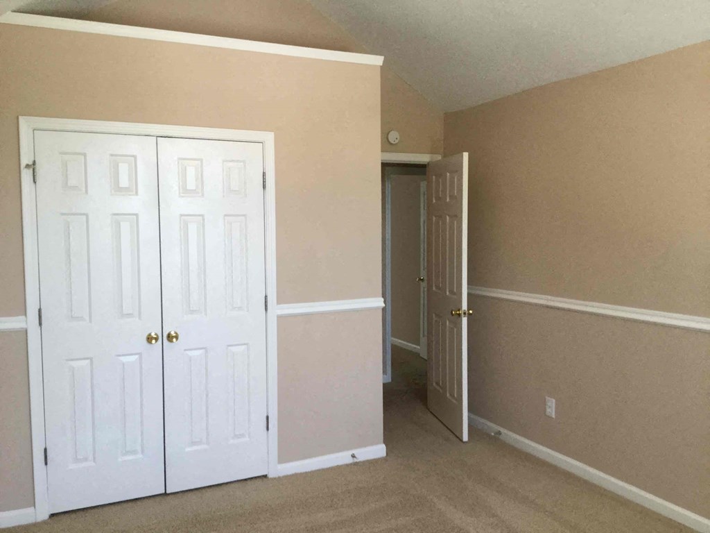 a bedroom with two closets and a door to a hallway