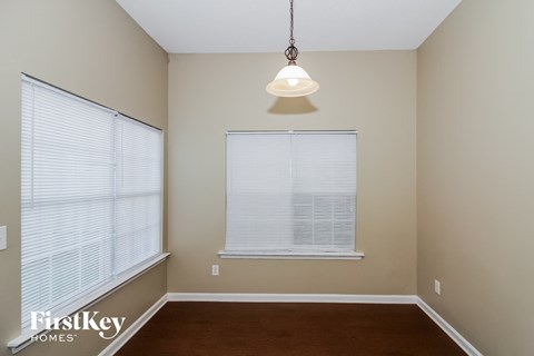 A room with a window and a light hanging from the ceiling.