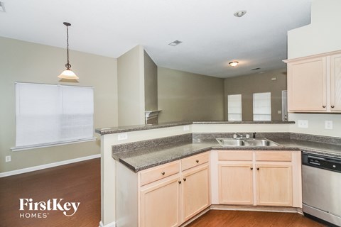 A kitchen with wooden cabinets and a granite countertop.