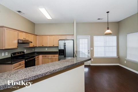 A kitchen with wooden cabinets and a granite countertop.
