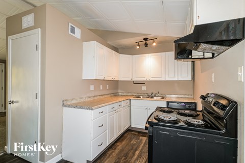a kitchen with white cabinets and black appliances and a stove