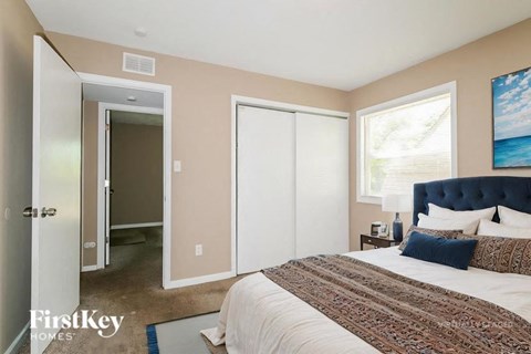 A bedroom with a large bed and a painting on the wall.