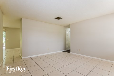 A spacious room with white walls and tiled floor.
