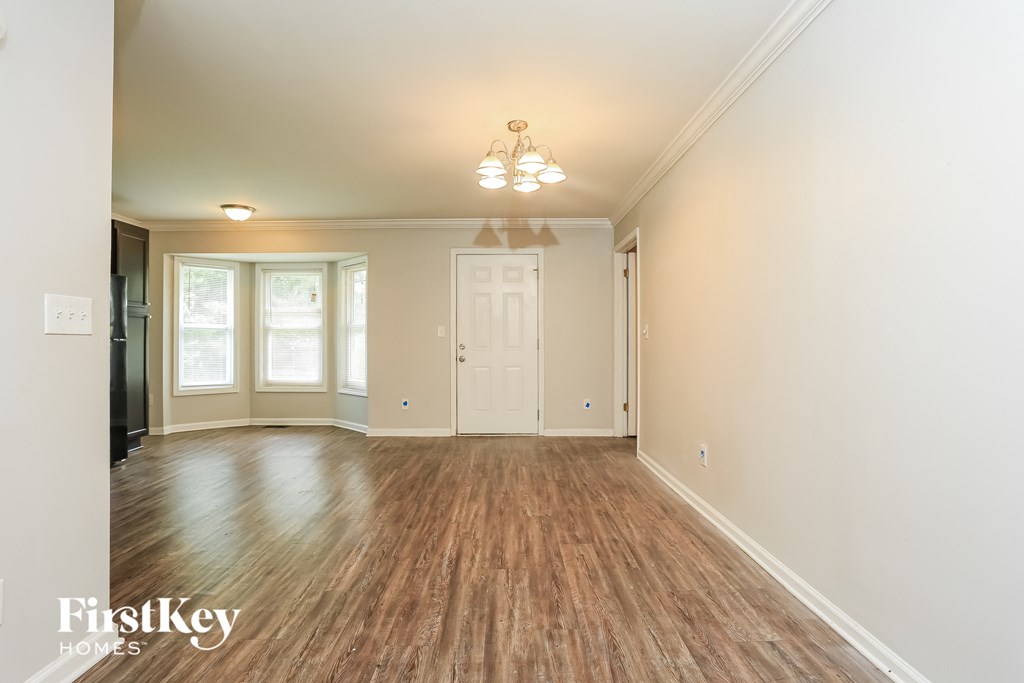 an empty living room with wood floors and a white door