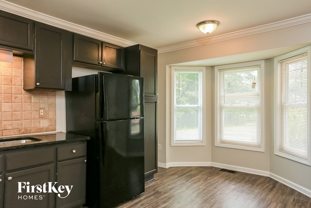 a kitchen with black appliances and a large window