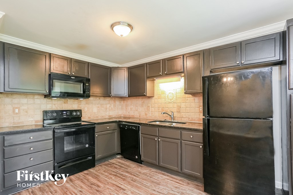 a kitchen with black appliances and stainless steel appliances
