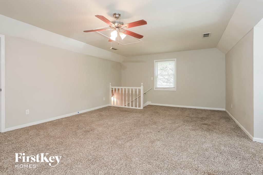 the master bedroom has carpeted floors and a ceiling fan