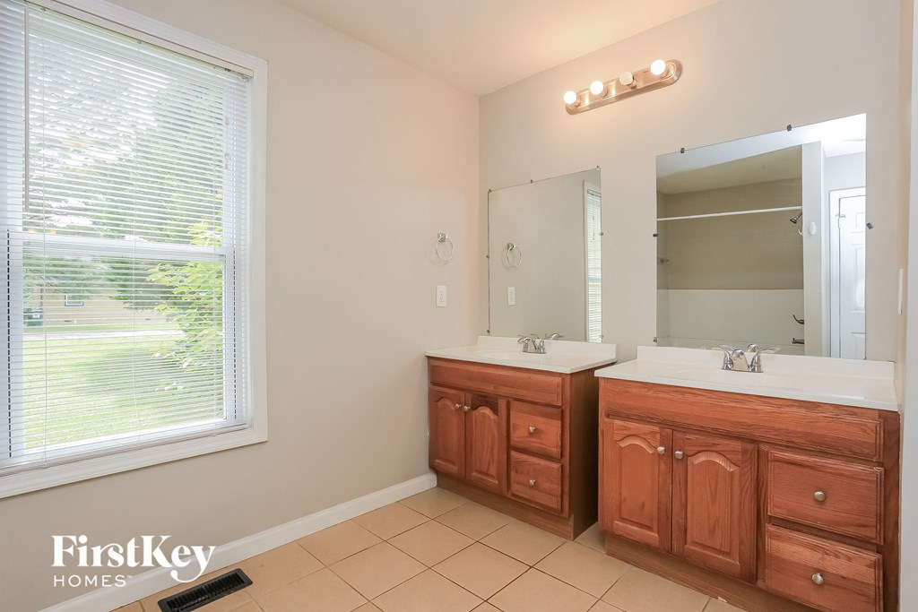a bathroom with two sinks and a large window