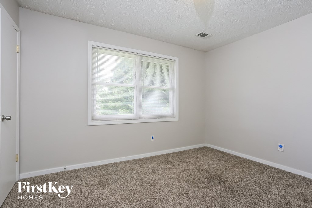 the living room of a home with carpet and a window
