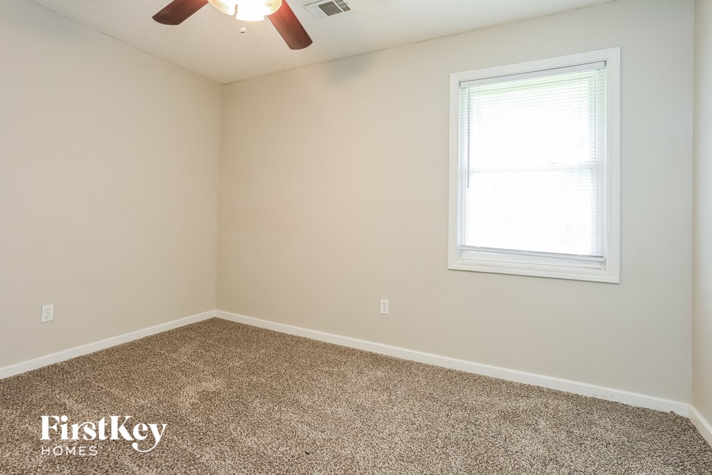 a bedroom with a carpeted floor and a window