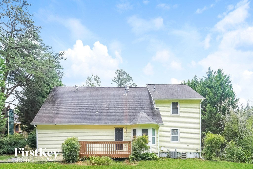 a yellow house with a porch and a gray roof
