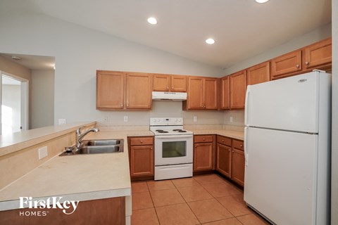 A kitchen with wooden cabinets and a white refrigerator.