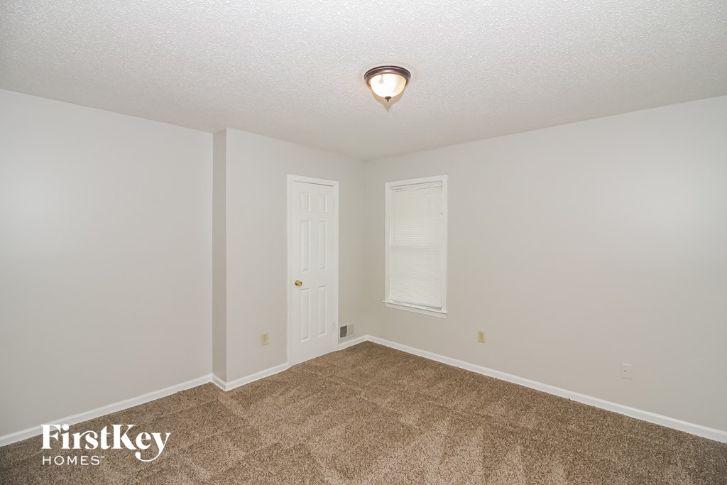 the spacious living room with carpeting and a white door