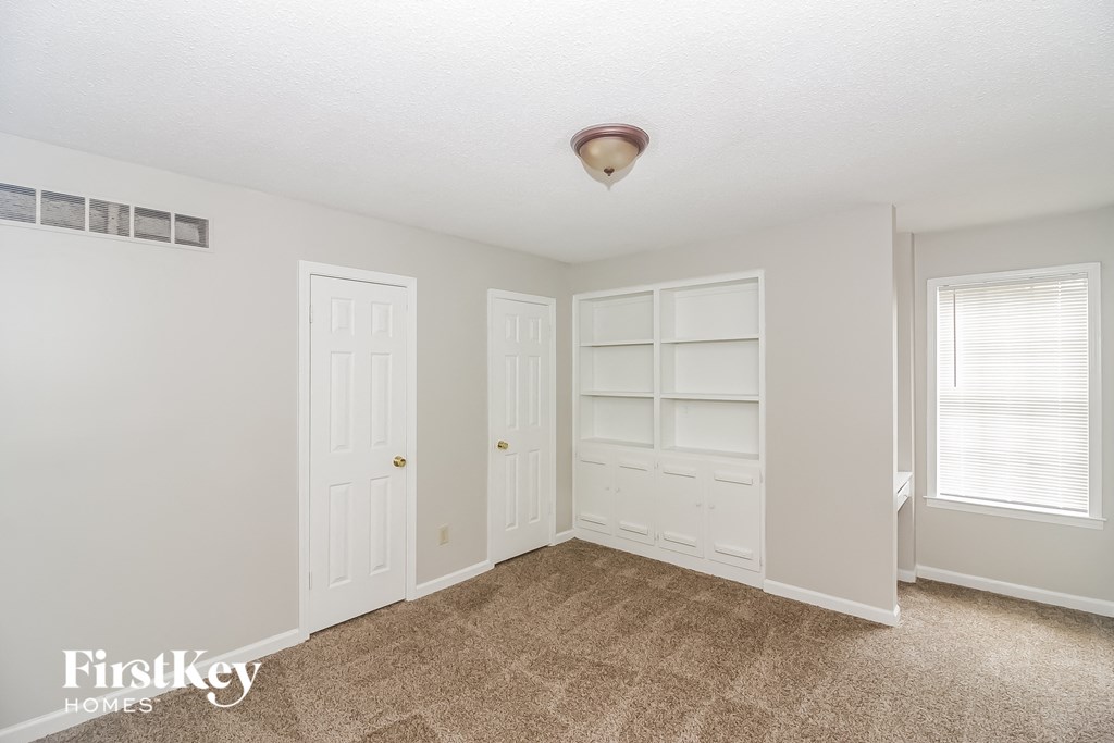 a bedroom with two closets and a carpeted floor