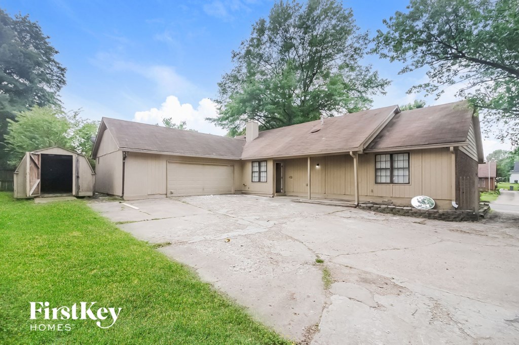 a beige house with a driveway and a garage door