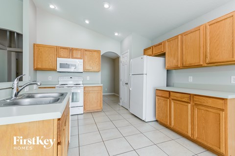 A kitchen with wooden cabinets and a white fridge.