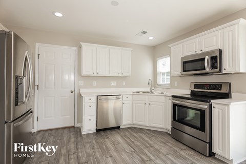 A kitchen with white cabinets and stainless steel appliances.