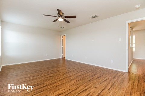 a living room with wood flooring and a ceiling fan