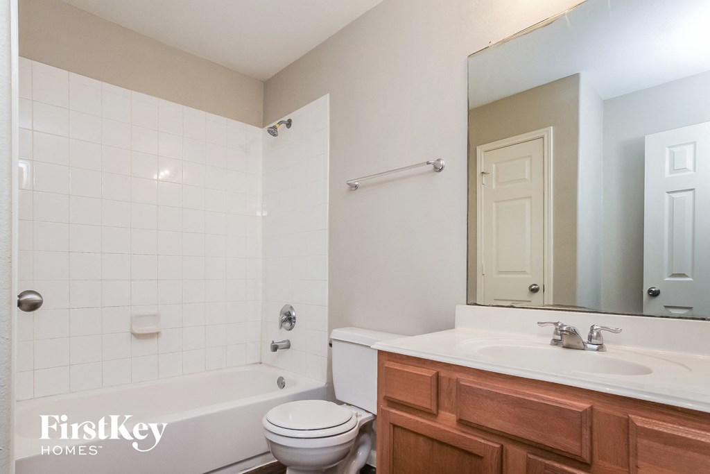 a bathroom with a toilet sink and tub and a mirror
