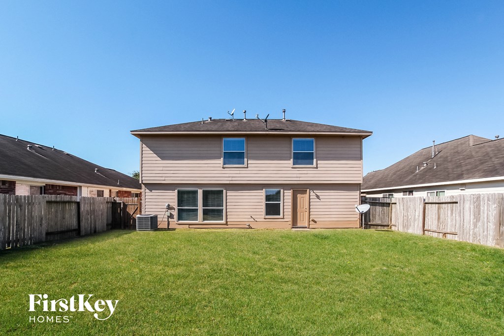the back of a house with a yard and a fence