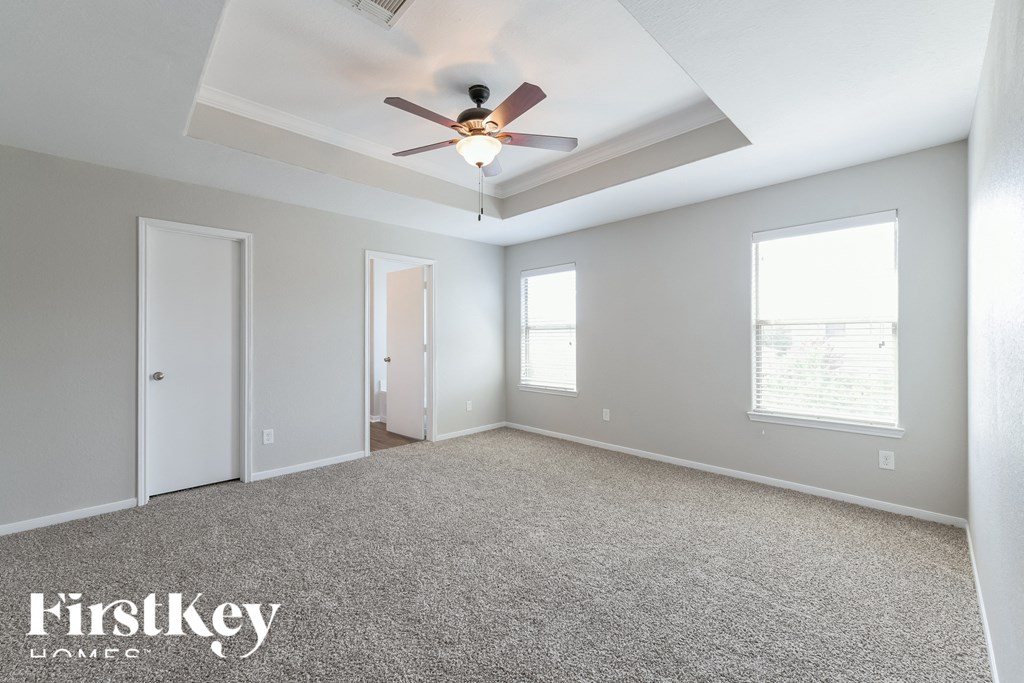 an empty room with a ceiling fan and a window