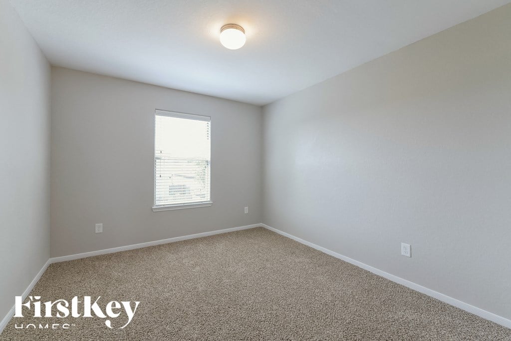the upstairs bedroom has carpet and a window