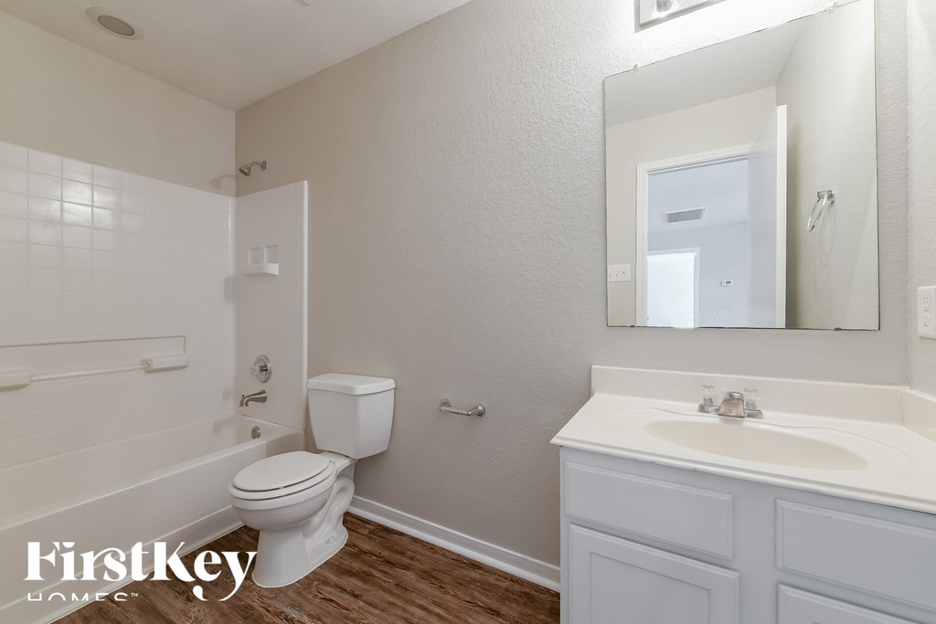 a bathroom with a toilet and a sink and a mirror