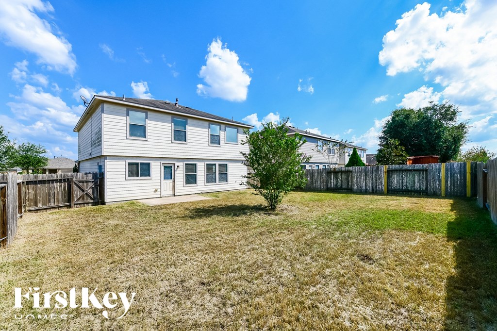 a white house with a yard and a fence