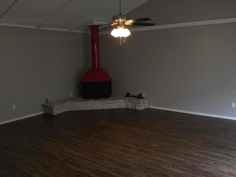 a living room with a fireplace and a ceiling fan
