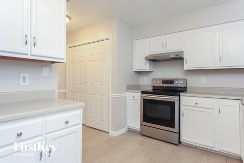 A kitchen with white cabinets and a stainless steel oven.