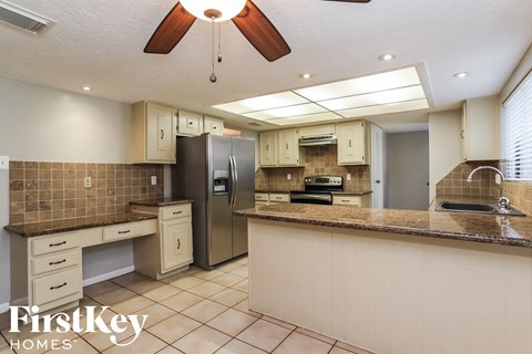 A kitchen with a tile floor and a tile backsplash.